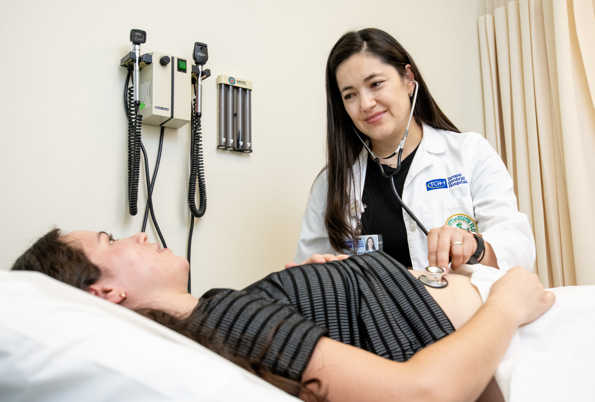 Dr. Encalada-Soto examines a patient with a stethoscope