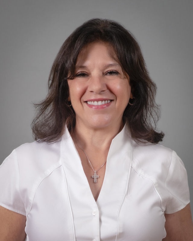 Ercilia Colon smiling wearing a white blouse